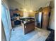 Well-lit kitchen featuring an island, tile floors, granite countertops and stainless steel appliances at 1934 St James Pl, Columbus, IN 47201