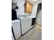 Laundry room with modern, white front-loading machines and wood cabinets above at 1934 St James Pl, Columbus, IN 47201