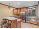 Basement bar area with stainless steel refrigerator, microwave, sink and seating for three at 2163 Laurel Leaf Ln, Avon, IN 46123