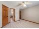 Bright bedroom boasts neutral walls, plush carpet, ceiling fan, and wood door to bathroom at 2163 Laurel Leaf Ln, Avon, IN 46123