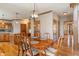 Dining room with hardwood floors, modern lighting, and access to the kitchen area at 2163 Laurel Leaf Ln, Avon, IN 46123