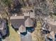 Aerial shot displaying the home's roof, deck, mature trees, and backyard layout in a peaceful setting at 2215 Van Ness Pl, Indianapolis, IN 46240