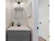 Modern bathroom with gray vanity, round mirror, updated fixtures, and a tiled backsplash at 2215 Van Ness Pl, Indianapolis, IN 46240