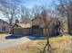 Charming home featuring a two-car garage, stone accents, and mature trees in a well-manicured lawn at 2215 Van Ness Pl, Indianapolis, IN 46240