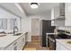 Updated kitchen with stainless steel appliances, white cabinets, quartz countertops, and wood-look flooring at 2215 Van Ness Pl, Indianapolis, IN 46240