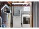 Basement laundry area with modern washer and dryer, utility sink, and exposed ductwork at 229 W Taylor St, Pendleton, IN 46064