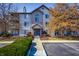 Attractive condo building with blue door, brick facade, and manicured landscaping under a bright sky at 240 Legends Creek # 206, Indianapolis, IN 46229