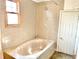 Bathroom with a tub, shower, tiled walls, and a window for natural light at 2839 E 19Th St, Indianapolis, IN 46218