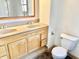 Bathroom featuring double sinks, wood cabinets, a window, and a toilet at 2839 E 19Th St, Indianapolis, IN 46218