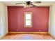 Bedroom features red accent wall, wood-look flooring, and natural light at 2839 E 19Th St, Indianapolis, IN 46218