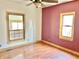 Bedroom featuring red accent wall, ceiling fan, wood-look flooring and window at 2839 E 19Th St, Indianapolis, IN 46218