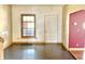 Living room with window, dark-stained wood flooring, and natural wood trim at 2839 E 19Th St, Indianapolis, IN 46218
