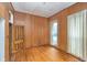 Bedroom with hardwood floors, wood-paneled walls, and natural light from windows at 300 S Market St, Thorntown, IN 46071