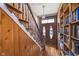Inviting entryway features wood-paneled walls, staircase, and stylish front door with adjacent bookshelves at 300 S Market St, Thorntown, IN 46071