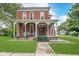 Charming two-story brick home featuring a spacious front porch and well-manicured lawn at 300 S Market St, Thorntown, IN 46071