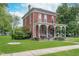 Classic brick home featuring a large front porch, green lawn, and inviting curb appeal at 300 S Market St, Thorntown, IN 46071