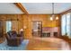 Cozy living room with wood paneling, brick fireplace, and hardwood floors at 300 S Market St, Thorntown, IN 46071