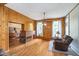Inviting living room featuring wood paneling, brick fireplace, and access to the dining room at 300 S Market St, Thorntown, IN 46071