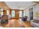 Bright living room featuring wood paneling, brick fireplace, and hardwood floors at 300 S Market St, Thorntown, IN 46071