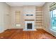 Spacious living room with hardwood floors and traditional-style fireplace with built-in shelves at 300 S Market St, Thorntown, IN 46071