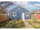 Exterior view of the backyard featuring a well-maintained blue-sided house with a concrete pathway at 301 Villa Ave, Indianapolis, IN 46201