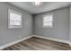 A gray bedroom with two windows and light wood-look flooring at 301 Villa Ave, Indianapolis, IN 46201