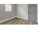 This bedroom features gray walls, wood floors, white trim, a window, and a closet door at 301 Villa Ave, Indianapolis, IN 46201