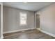 A gray bedroom with wood-look flooring and a white-trimmed window at 301 Villa Ave, Indianapolis, IN 46201