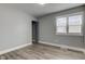 A gray bedroom featuring wood-look flooring, a window, and a door to a closet at 301 Villa Ave, Indianapolis, IN 46201