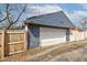 The side of a blue house features a garage door with a wooden fence in the background at 301 Villa Ave, Indianapolis, IN 46201