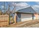 Garage door view with wooden fence, gravel driveway, and exterior walls with siding at 301 Villa Ave, Indianapolis, IN 46201