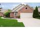 Front exterior view of a brick home with an attached two-car garage and a well maintained lawn at 3034 Tiffany Ct, Carmel, IN 46033