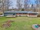 Aerial view of the backyard with lush grass, a deck, mature trees and the home at 405 W 73Rd St, Indianapolis, IN 46260