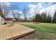 Backyard featuring a deck, trees, and a green lawn with a seating area in the background at 405 W 73Rd St, Indianapolis, IN 46260