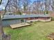 Aerial view of the backyard featuring a deck, a lawn, and mature trees surrounding the home at 405 W 73Rd St, Indianapolis, IN 46260