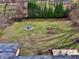 Aerial view of the backyard featuring a grass lawn, trees, and a stone fire pit area with chairs at 405 W 73Rd St, Indianapolis, IN 46260