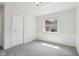 This bedroom features neutral carpet, white walls and trim, paneled wainscoting, a window, and a closet at 405 W 73Rd St, Indianapolis, IN 46260