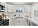 Well-lit kitchen with stainless appliances, white cabinetry and contemporary finishes at 405 W 73Rd St, Indianapolis, IN 46260