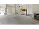 Bright open-concept living space with neutral carpet, fireplace, and seamless flow into kitchen at 4062 S Meadow Wood Ct, New Palestine, IN 46163