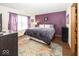 Comfortable bedroom with textured purple accent wall, large window, and wood-look flooring at 4238 Vestry Ct, Indianapolis, IN 46237