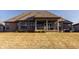 View of the back exterior featuring an enclosed porch, beautiful landscaping, and an expansive lawn at 4287 Prairie Falcon Dr, Zionsville, IN 46077