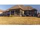 Well-maintained back exterior highlighting the enclosed porch, brickwork, and manicured lawn at 4287 Prairie Falcon Dr, Zionsville, IN 46077