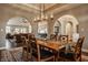 Open concept dining room with hardwood floors, area rug, modern chandelier, and arched entryways at 4287 Prairie Falcon Dr, Zionsville, IN 46077