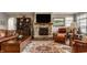 Warm living room featuring a stone fireplace, a large TV, comfortable seating, and stylish décor at 4287 Prairie Falcon Dr, Zionsville, IN 46077