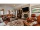 Well-appointed living room featuring a stone fireplace, a large TV, comfortable seating, and stylish decorative elements at 4287 Prairie Falcon Dr, Zionsville, IN 46077