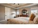 Main bedroom with tray ceiling, large bed, dresser, and a comfortable leather chair at 4287 Prairie Falcon Dr, Zionsville, IN 46077