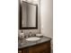 Powder room featuring a black granite countertop, framed mirror, and under sink vanity at 4287 Prairie Falcon Dr, Zionsville, IN 46077