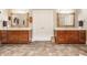Bathroom with dual wooden vanities, decorative mirrors, and tile flooring showcasing a clean, classic design at 438 E Vermont St, Indianapolis, IN 46202