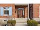 Elegant front entrance showcasing a wooden door with glass detailing and manicured landscaping at 438 E Vermont St, Indianapolis, IN 46202
