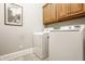 Laundry room with a washer, dryer, and overhead storage cabinets at 438 E Vermont St, Indianapolis, IN 46202